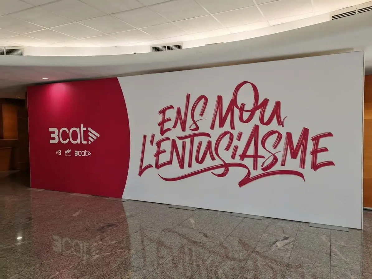 Mural corporativo de 3cat con lema caligráfico