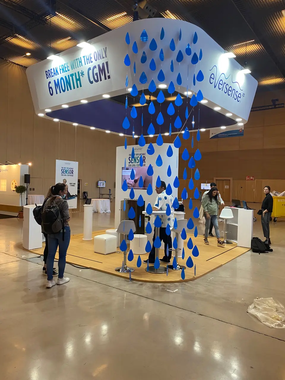 Stand de Eversense con columna central de gotas azules