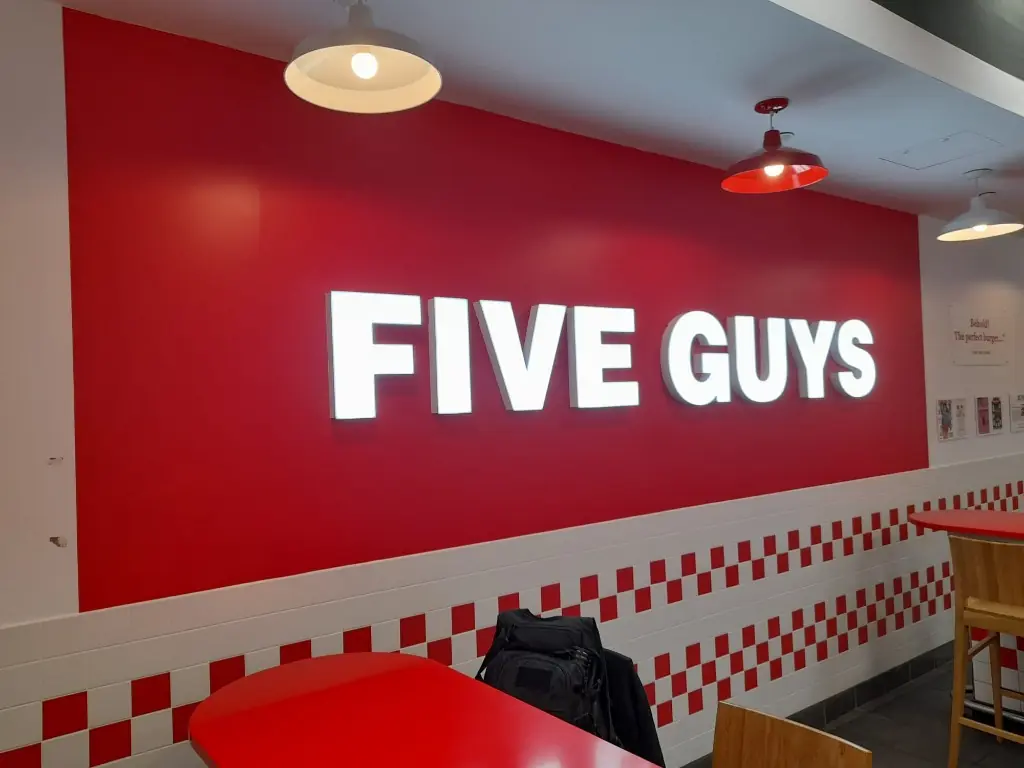 Interior de Five Guys con rótulo y gráfica roja